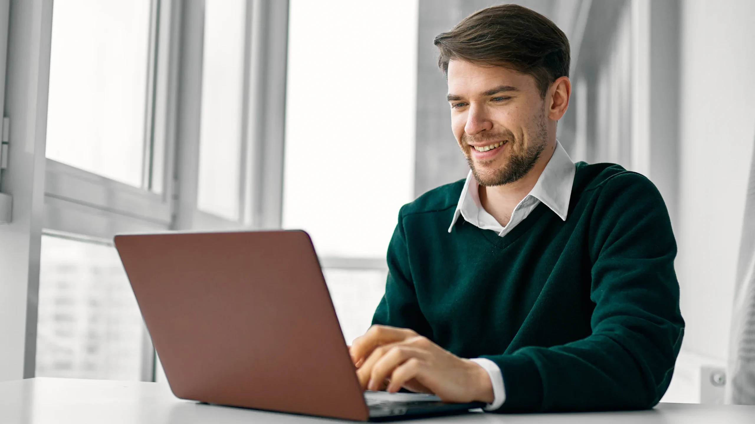 Ein Mann mit einem Laptop in einer Büroumgebung.