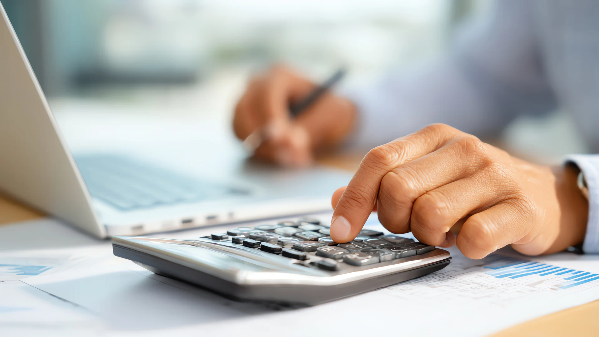 Hand, die einen Taschenrechner benutzt